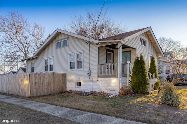 view of home's exterior featuring covered porch and fence