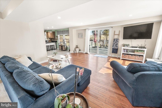 living room with recessed lighting, light wood-type flooring, and baseboards