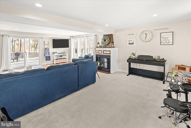 carpeted living room featuring a glass covered fireplace, recessed lighting, and baseboards