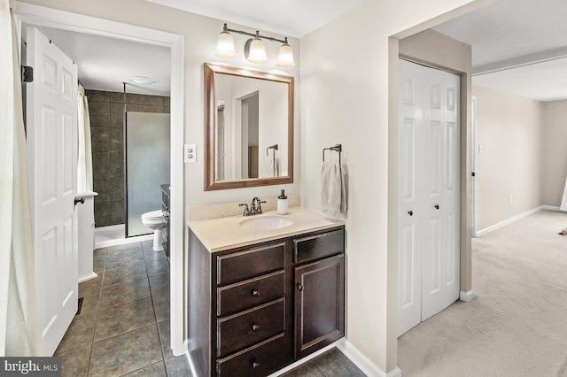 bathroom with vanity, toilet, baseboards, and tile patterned flooring