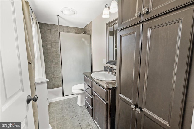 full bathroom featuring vanity, tile patterned floors, toilet, and tiled shower