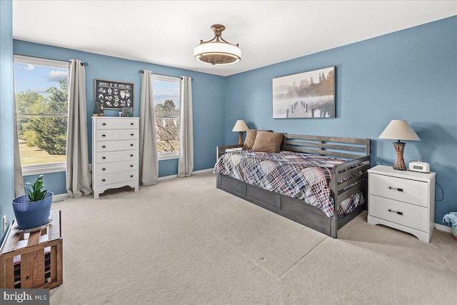 carpeted bedroom with multiple windows and baseboards