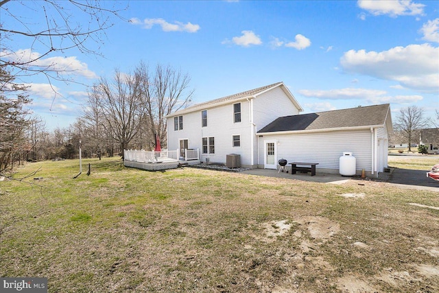 rear view of property featuring central air condition unit, a lawn, and a wooden deck