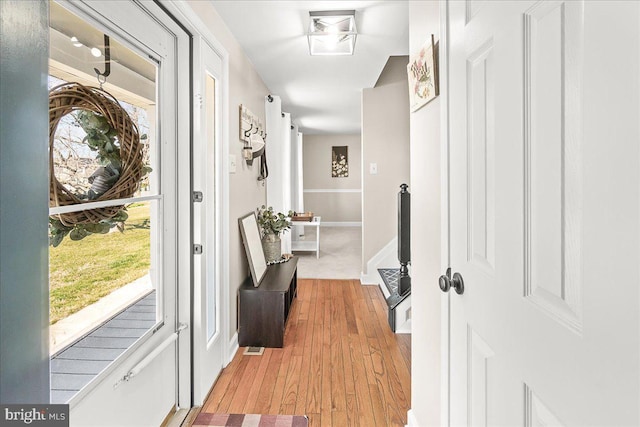 hallway with baseboards and light wood-style floors