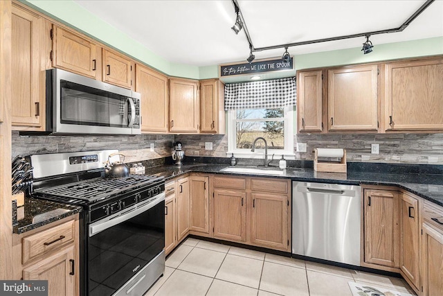 kitchen featuring light tile patterned flooring, stainless steel appliances, tasteful backsplash, and a sink