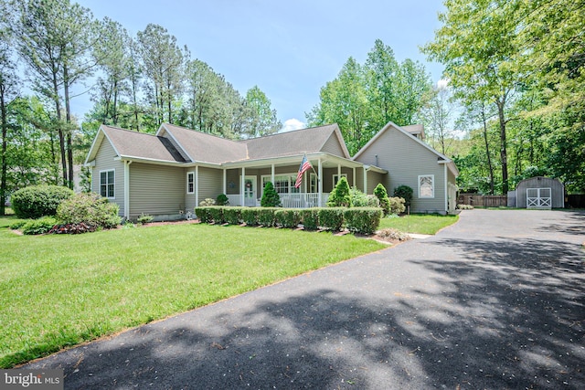 17024 Turtle Hl, Milford, DE 19963 - ranch-style home featuring covered porch, aphalt driveway, an outbuilding, a shed, and a front lawn