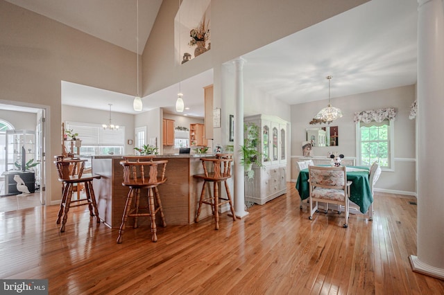 17024 Turtle Hl, Milford, DE 19963 - dining space featuring baseboards, decorative columns, light wood-style flooring, and a notable chandelier