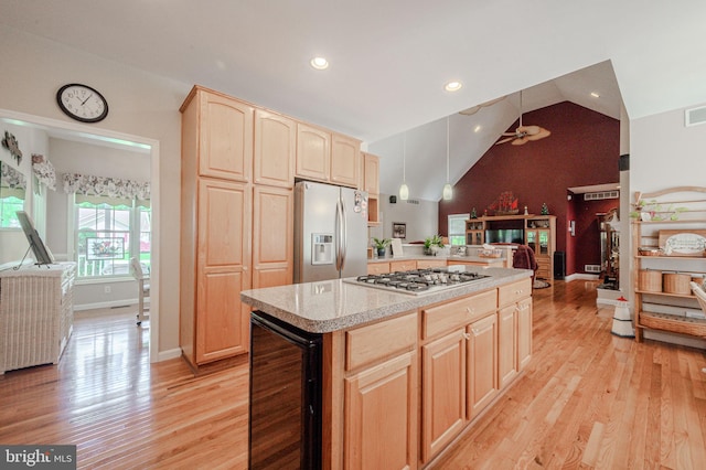 17024 Turtle Hl, Milford, DE 19963 - kitchen featuring light brown cabinetry, appliances with stainless steel finishes, light countertops, lofted ceiling, and wine cooler