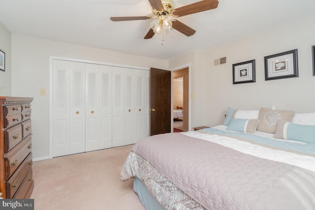 bedroom with baseboards, visible vents, ceiling fan, a closet, and light colored carpet