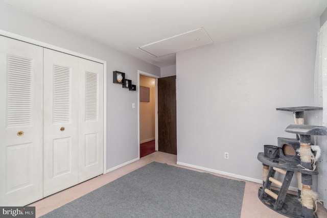 interior space featuring attic access, carpet, and baseboards