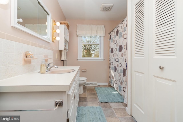 full bathroom with visible vents, toilet, a closet, decorative backsplash, and vanity