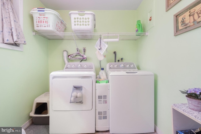 washroom with laundry area, washer and dryer, and baseboards