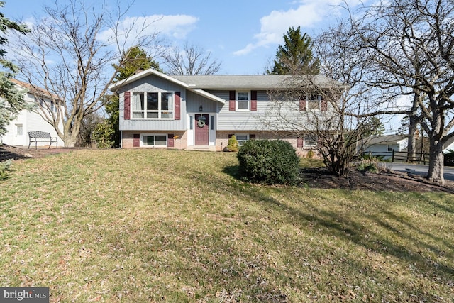 bi-level home with brick siding and a front yard