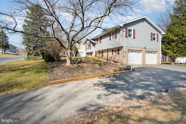 view of front facade with a garage, brick siding, and driveway