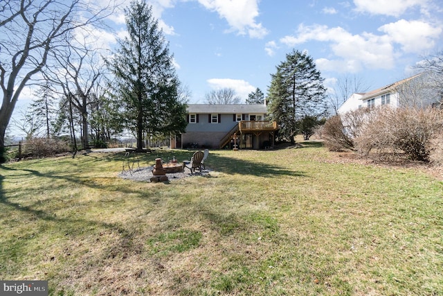 view of yard featuring an outdoor fire pit, stairs, and a deck