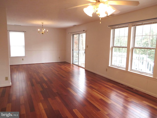 empty room featuring wood-type flooring, baseboards, and ceiling fan with notable chandelier