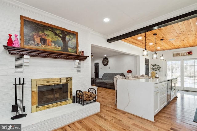 3524 Blenheim Rd, Phoenix, MD 21131 - kitchen featuring beam ceiling, white cabinetry, crown molding, light wood finished floors, and a brick fireplace