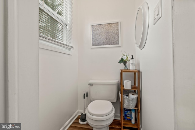 bathroom with wood finished floors, toilet, and baseboards