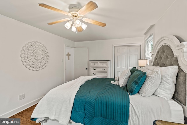 bedroom with ceiling fan, baseboards, a closet, and wood finished floors