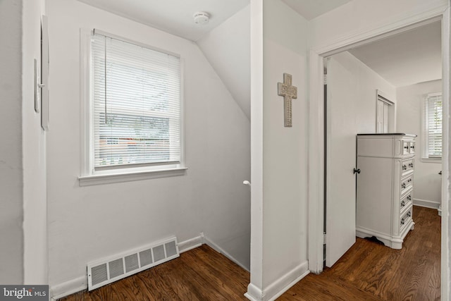 hallway featuring wood finished floors, visible vents, and baseboards