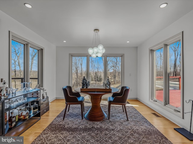 dining room with a chandelier, light wood-type flooring, visible vents, and recessed lighting