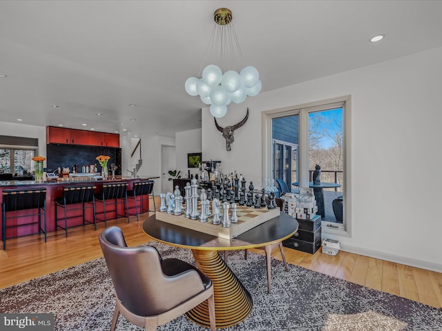 dining room featuring recessed lighting, a bar, and wood finished floors