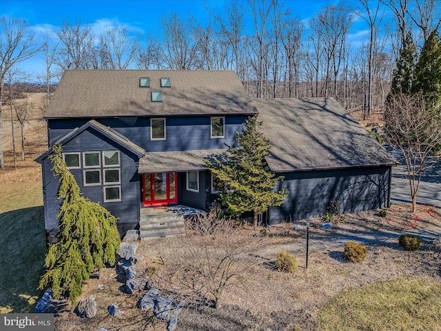 view of front of home featuring a shingled roof and driveway