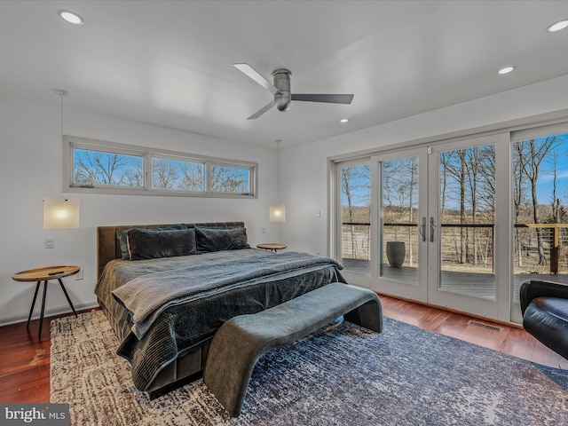 bedroom featuring access to outside, multiple windows, visible vents, and wood finished floors