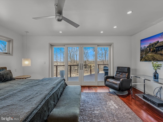 bedroom featuring access to exterior, recessed lighting, multiple windows, and wood finished floors