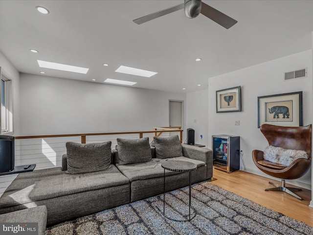 living area with a ceiling fan, visible vents, wood finished floors, and recessed lighting