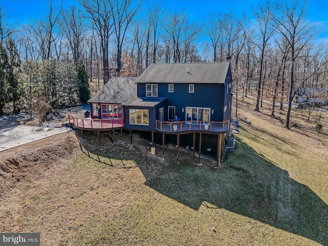 back of property featuring a deck and a yard