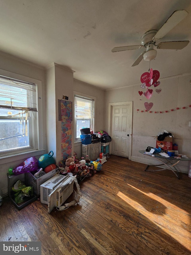 recreation room featuring ceiling fan, ornamental molding, and hardwood / wood-style floors