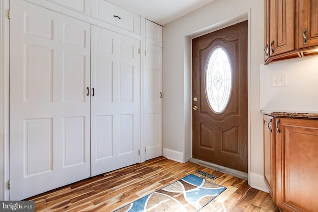 entryway featuring light wood finished floors, visible vents, and baseboards