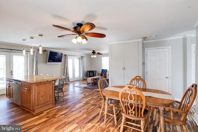 dining room with french doors, crown molding, and wood finished floors