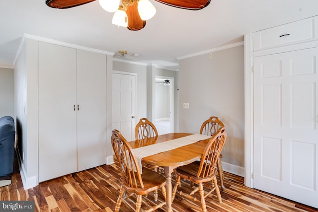 dining room featuring baseboards, ceiling fan, ornamental molding, and wood finished floors