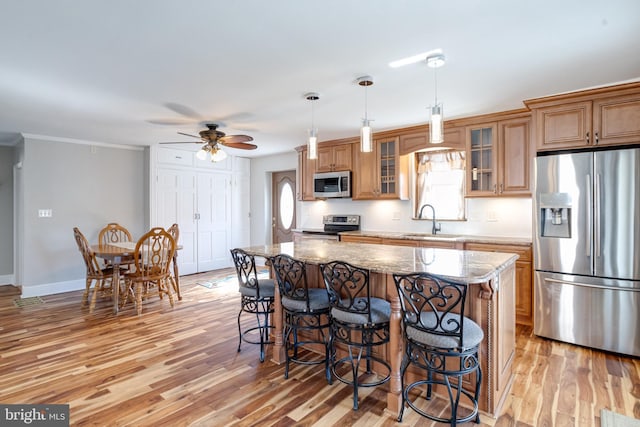 kitchen with a breakfast bar, a kitchen island, stainless steel appliances, and a sink