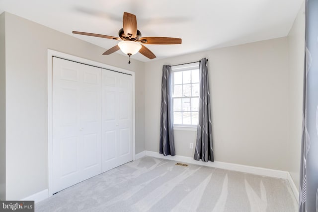 unfurnished bedroom with baseboards, a closet, visible vents, and light colored carpet