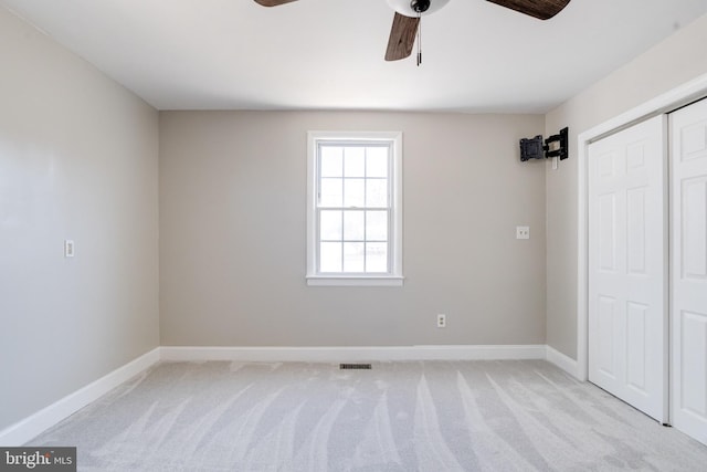 unfurnished bedroom featuring light carpet, baseboards, visible vents, and a closet