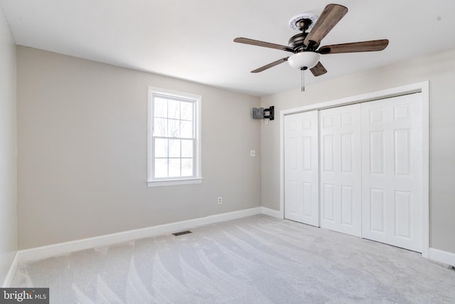 unfurnished bedroom featuring visible vents, baseboards, a ceiling fan, carpet floors, and a closet