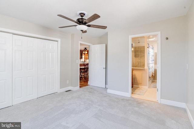 unfurnished bedroom with baseboards, a ceiling fan, ensuite bathroom, carpet flooring, and a closet