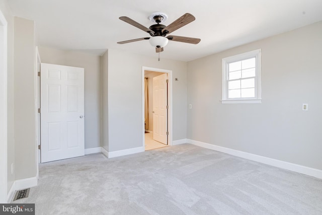 unfurnished bedroom featuring light carpet, baseboards, visible vents, and a ceiling fan