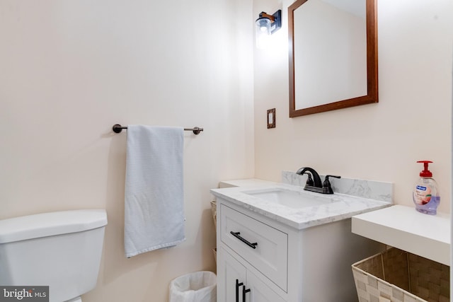 half bathroom with vanity and toilet