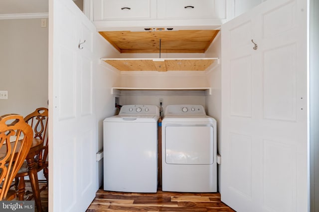 laundry area featuring ornamental molding, washer and dryer, laundry area, and wood finished floors