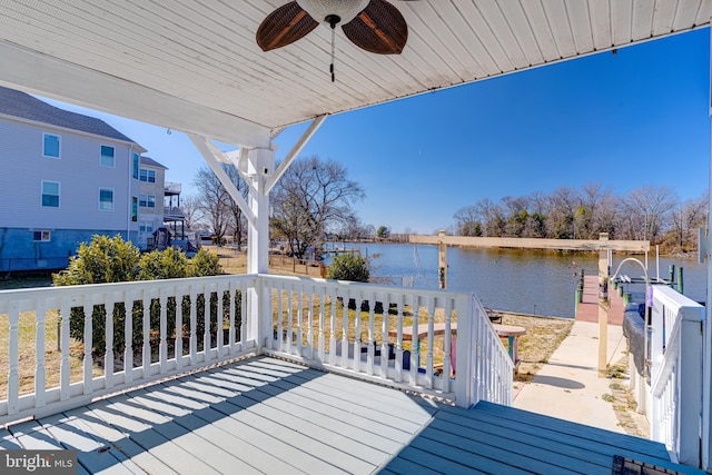 wooden terrace featuring ceiling fan, a boat dock, and a water view