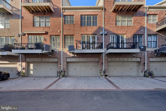 rear view of house featuring driveway and brick siding