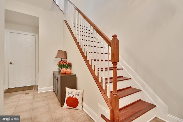 staircase featuring baseboards and tile patterned floors