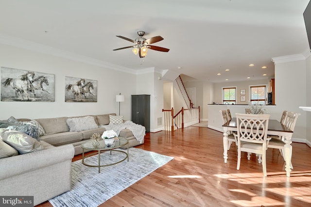 living room featuring recessed lighting, baseboards, stairs, ornamental molding, and light wood finished floors