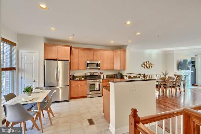 kitchen featuring stainless steel appliances, dark countertops, visible vents, and recessed lighting