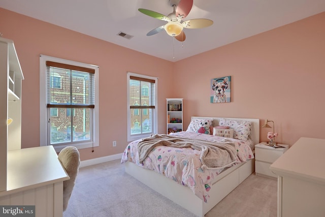 bedroom featuring a ceiling fan, visible vents, light carpet, and baseboards