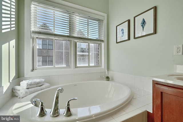 full bath featuring a wealth of natural light, vanity, and a bath